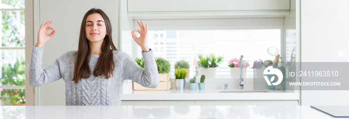 Wide angle picture of beautiful young woman sitting on white table at home relax and smiling with ey