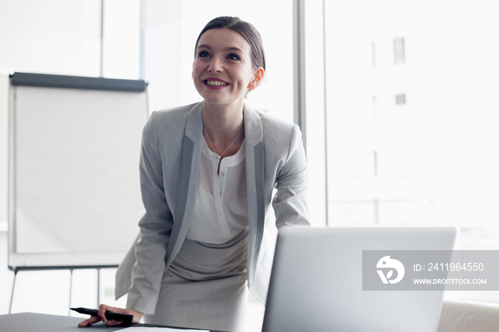 Smiling corporate businesswoman preparing for meeting at laptop