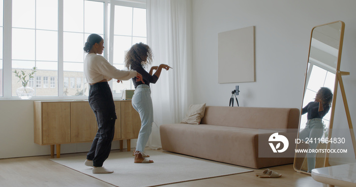 Two African-American Black girls recording trendy dance moves for social media account