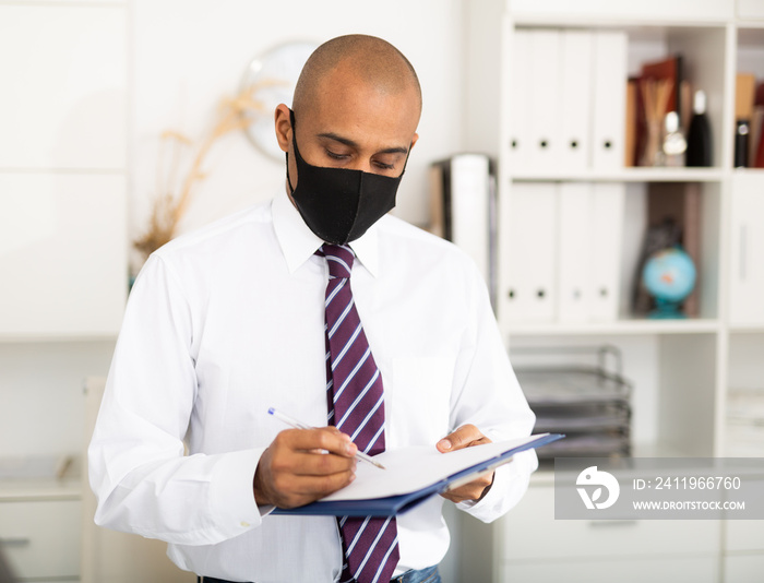 商人或办公室工作人员正在工作，戴口罩以保护新冠肺炎或冠状病毒病