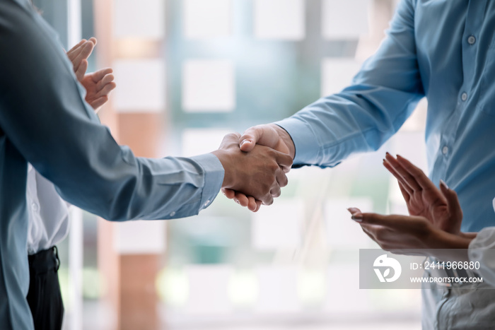 Teamwork of business people at meeting shaking hands to seal a deal with his partner.