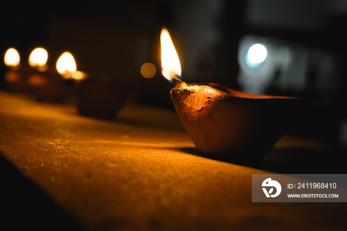 Raw of Burning Diya Clay Lamp. Diwali celebration background. Illuminated diya oil clay lamp during 