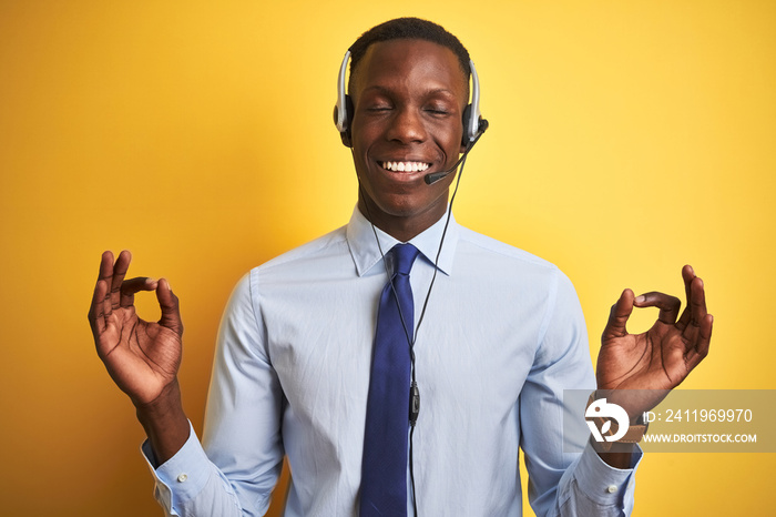 African american operator man working using headset over isolated yellow background relax and smilin