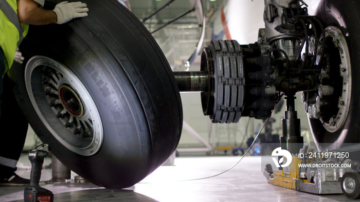 Airport worker checking chassis. Engine and chassis of the passenger airplane under heavy maintenanc