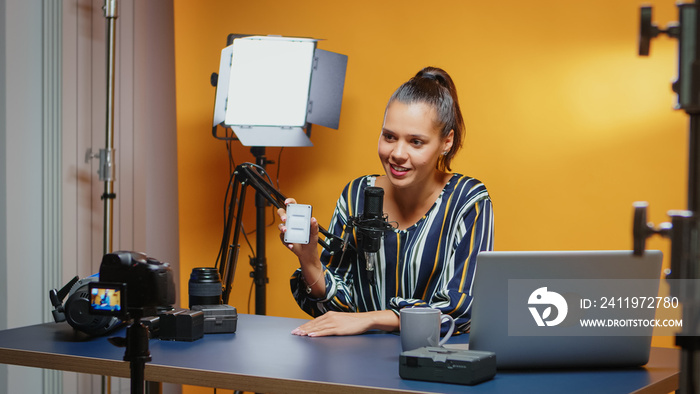 Social media influencer doing a mini Led light review in professional studio. Video blogger recordin