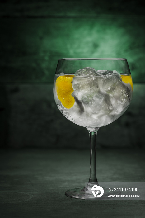 Gin and tonic cocktail on a wooden table with background