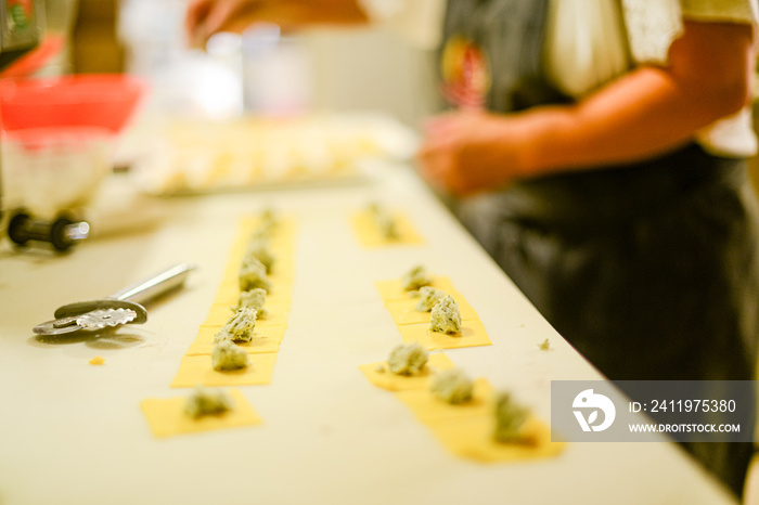 person making tortelli, traditional italian stuffed pasta,  in the kitchen