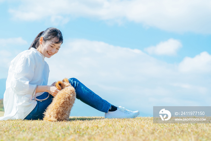 愛犬と遊ぶ女性（芝生・座る）