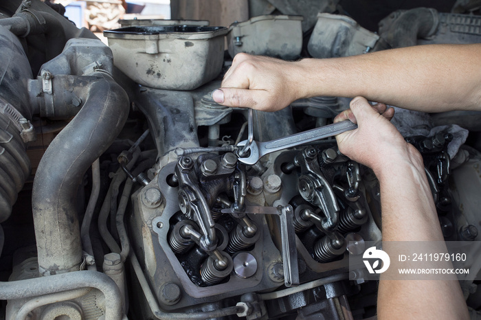 Mechanic repairs a truck.  adjustment of valves of the diesel motor.  Replacement nozzles.