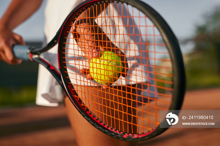 Crop woman playing tennis on court