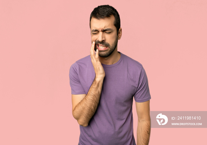 Handsome man with toothache on isolated pink background