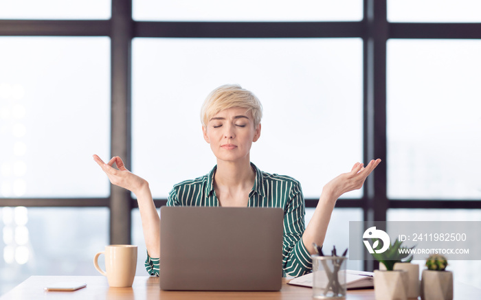 Peaceful Businesswoman Relaxing Meditating Sitting At Workplace In Office