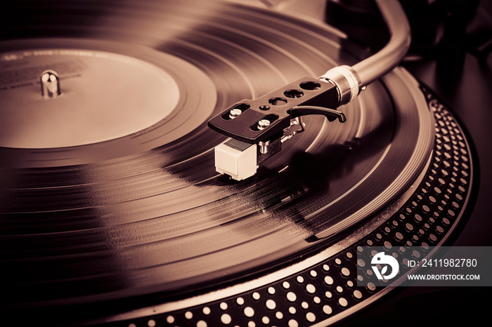 A needle on a turntable that plays music