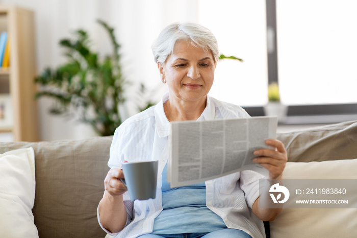 老年、休闲和人的概念——快乐的老年女性喝咖啡或茶，阅读新闻报纸