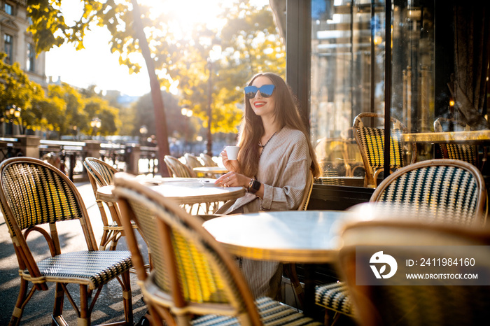 一位年轻女性在传统的法国咖啡馆享受咖啡的肖像