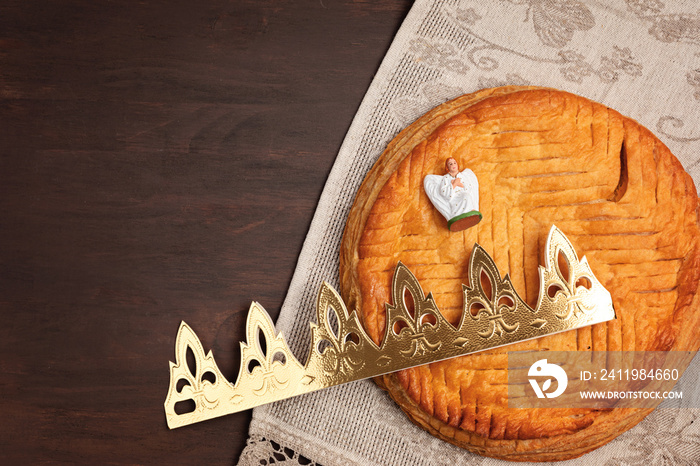 King cake or galette des rois in French. Traditional epiphany pie with golden paper crown and tiny c