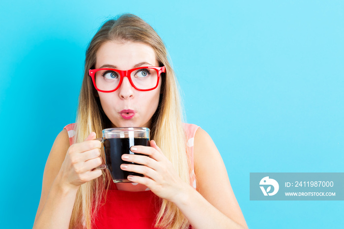 Happy young woman drinking coffee