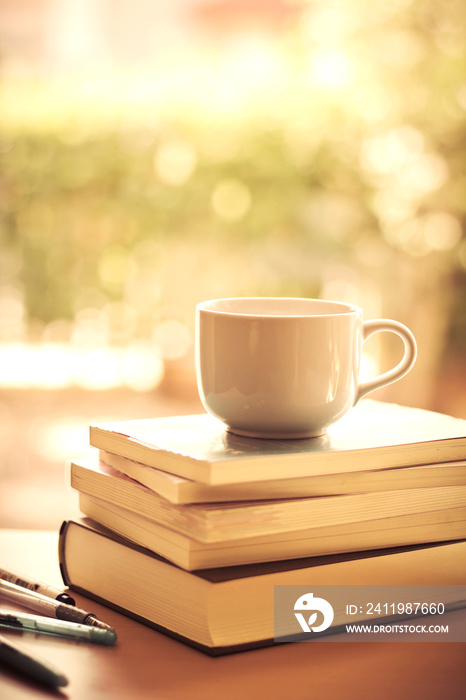 selective focus of white coffee cup and  books stacking