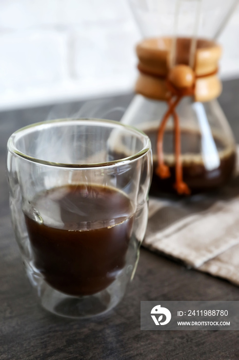 Glass of hot coffee on table