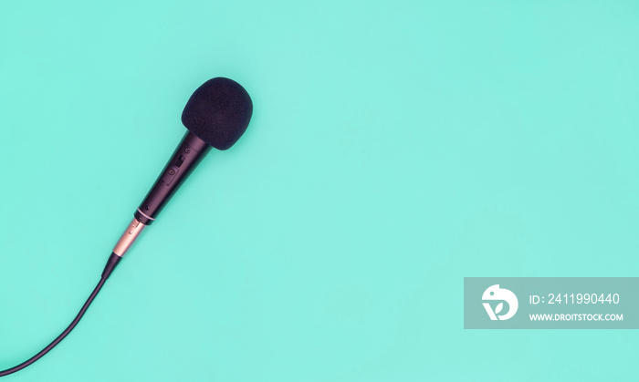 Black microphone on blue teal background for music concept