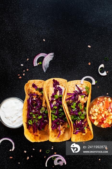 Traditional Mexican tacos with chicken, grilled vegetables, onions and purple cabbage, served with w