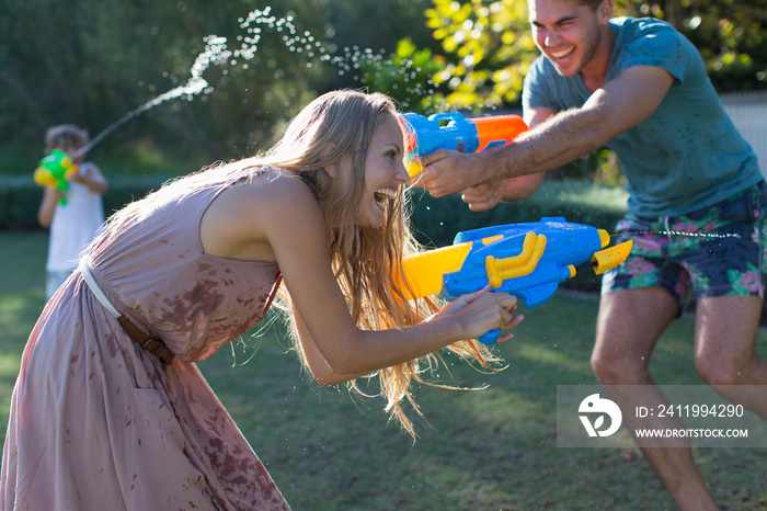 Playful family with squirt guns in backyard