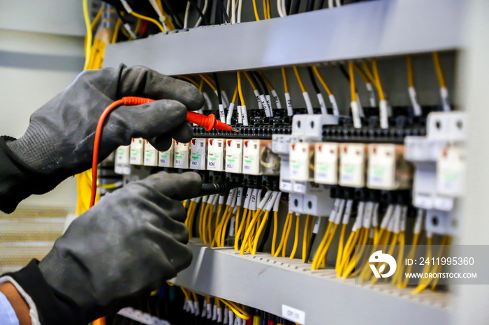 电气工程师使用数字万用表测量设备检查电流电压
