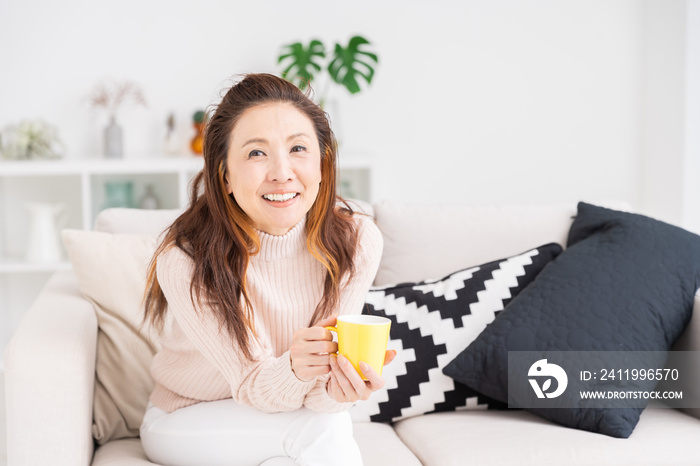 部屋でリラックスするシニア女性　飲み物