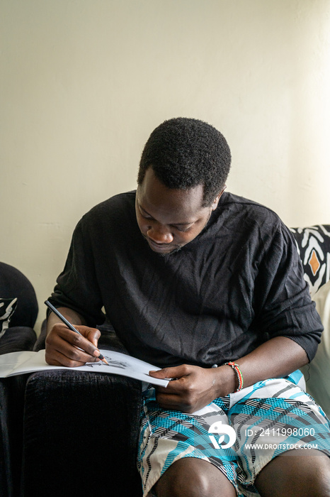 man drawing while seated on a couch