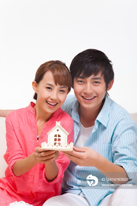 年轻情侣拿着房子模型