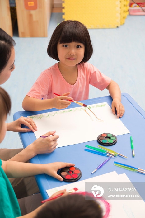 幼儿园女老师辅导儿童画画