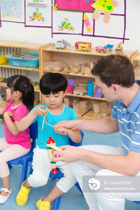 幼儿园老师和儿童一起演奏乐器