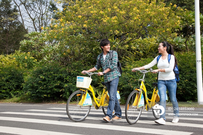 年轻大学生在校园里推车