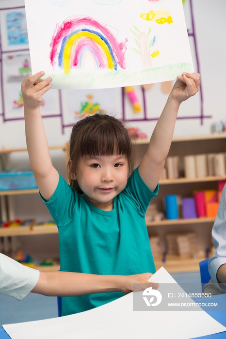 幼儿园女老师和儿童展示绘画作品