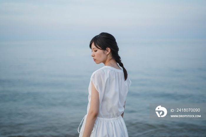 夕暮れの海の女性