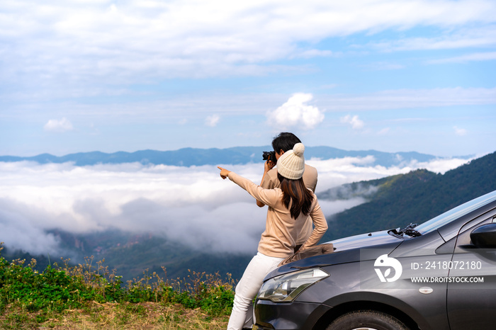 年轻的女性旅行者开车在山上欣赏美丽的雾海，开车旅行