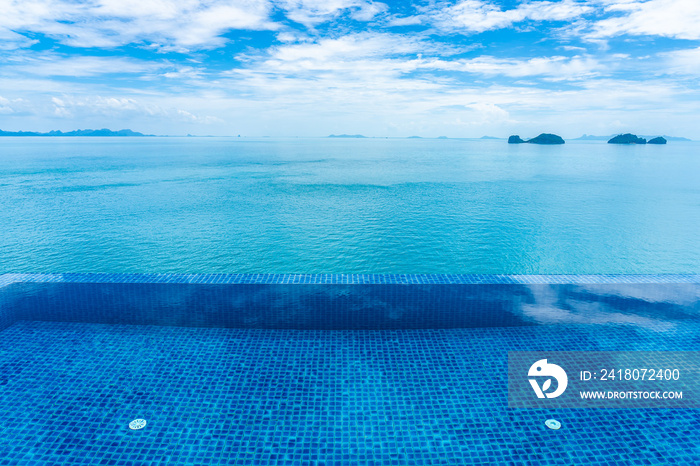 Beautiful outdoor swimming pool with sea ocean on white cloud blue sky background