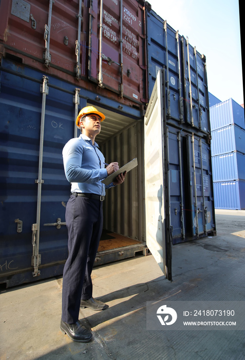 Engineer or supervisor checking and control loading Containers box from Cargo at harbor.Foreman cont