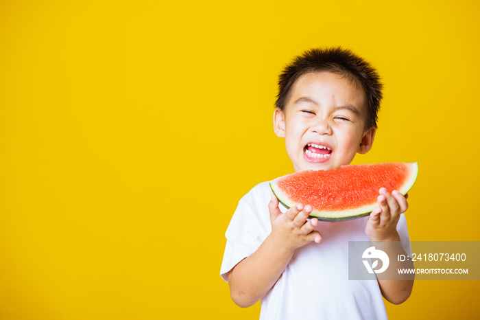 孩子可爱的小男孩迷人的笑声玩耍拿着切好的西瓜吃