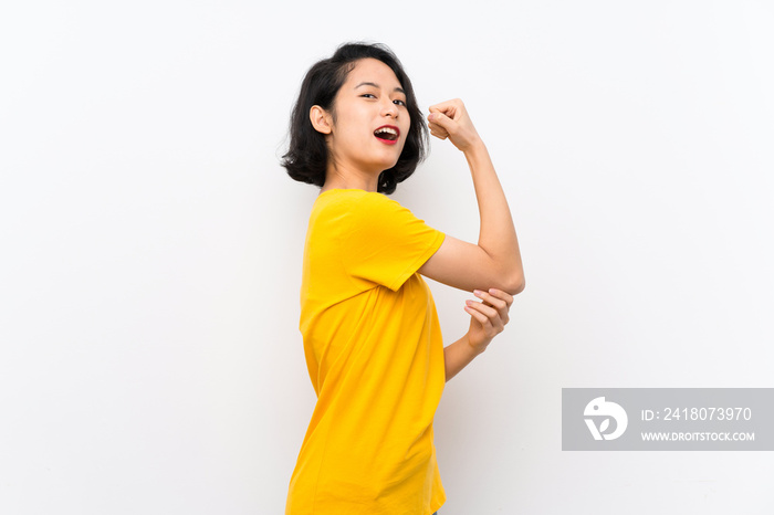 Asian young woman over isolated white background doing strong gesture