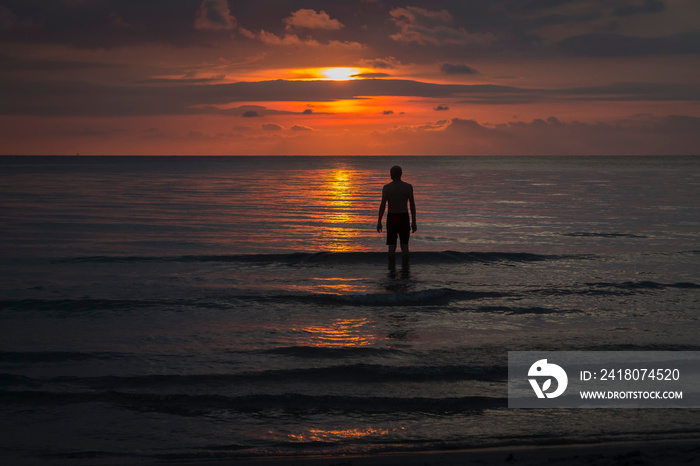 standing in the asian sea at sunset