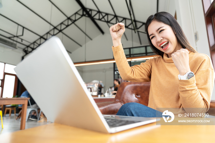 Young attractive asian woman looking at laptop computer feeling happy cheerful or excited in project