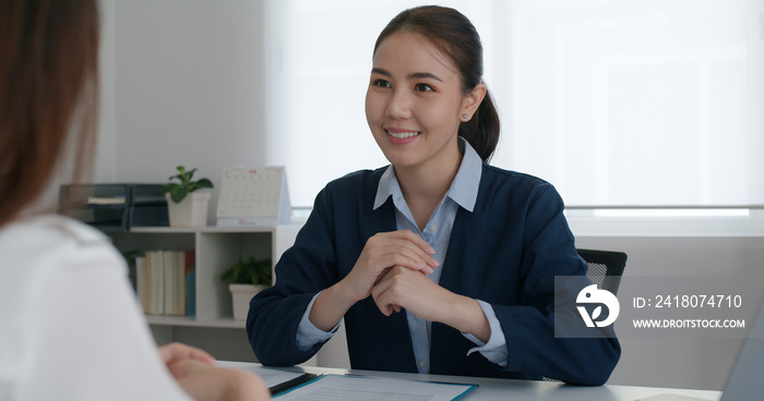亚洲女性房地产销售代理或交易员建议坐在律师办公室的桌子上微笑信任交谈i