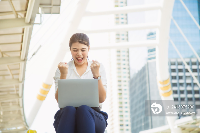 happy Asian woman in casual white shirt sitting on floor celebrate with laptop from a good news at m