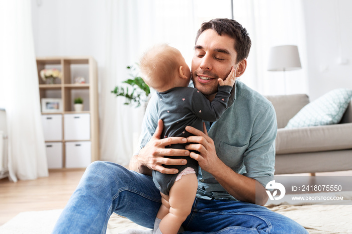 family, fatherhood and people concept - happy father with little baby daughter at home