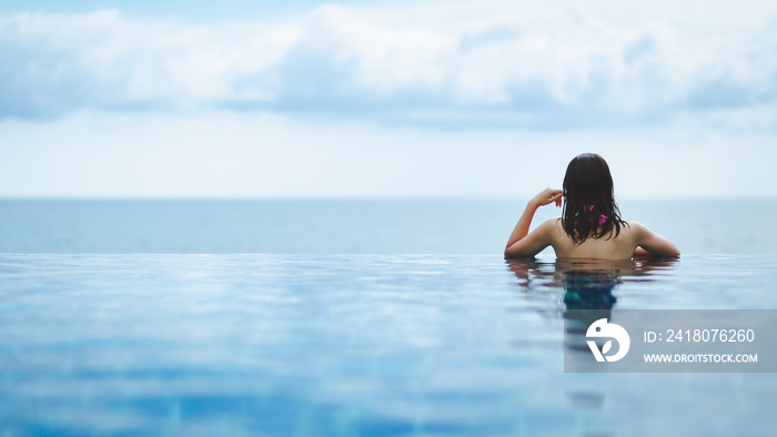 Asian woman relax in pool on beach