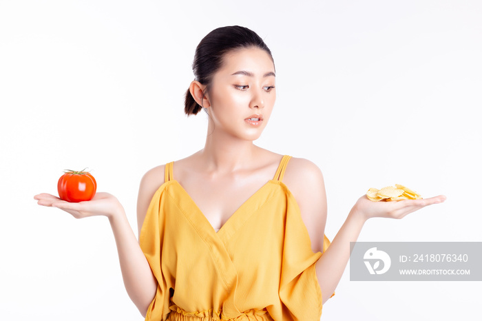 Diet concept. Beautiful young asian woman looks at delicious snack, potato chip. Attractive girl con