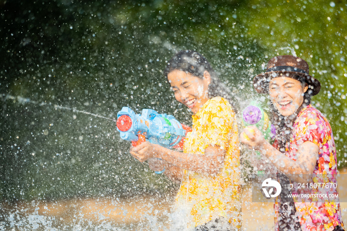 Asian people are using water guns play songkran festival in the summer april