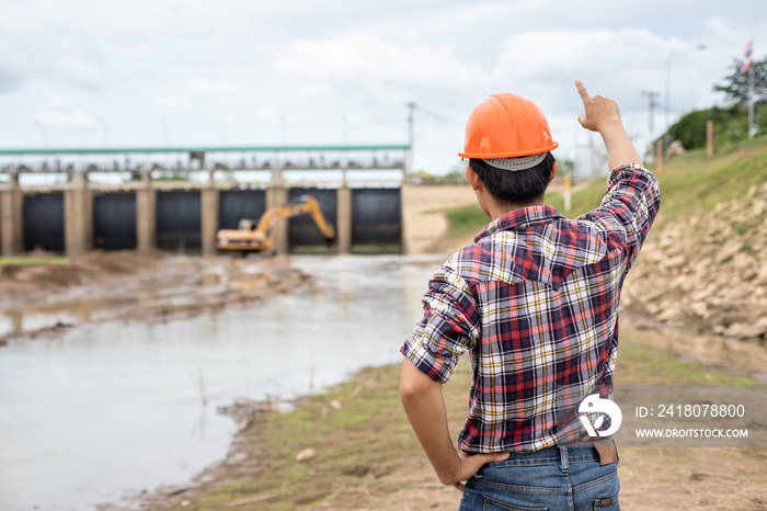 Young engineer working on site at the dam