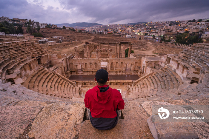 A man traveller sitting on top of Roman theater in Jerash ruin and ancient city of Roman empire in A